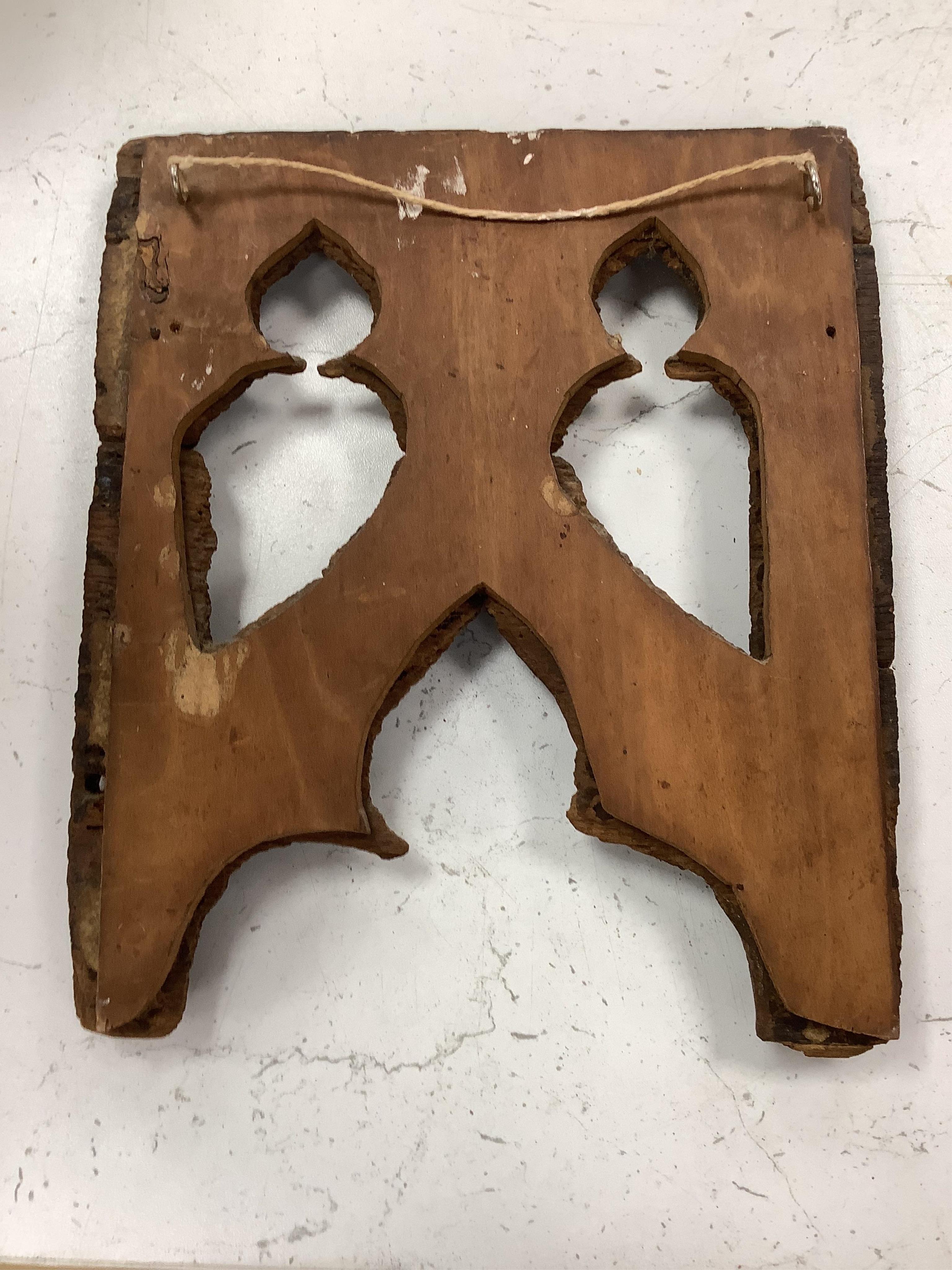 A 19th century leather binding for a book, 35cm high x 33.5cm wide, two carved gothic panels and a carved figure